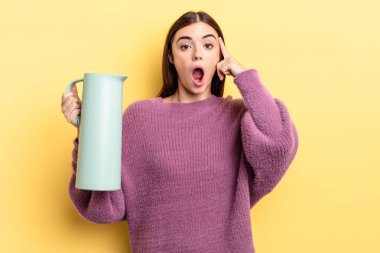 Genç İspanyol kadın şaşırmış görünüyor, yeni bir düşünce, fikir ya da konsept keşfediyor. Kahve termosu kavramı