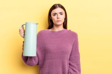 Genç İspanyol kadın üzgün ve mızmızlanıyor. Mutsuz bir bakışı var ve ağlıyor. Kahve termosu kavramı