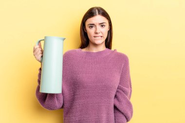 Genç İspanyol kadın şaşkın ve şaşkın görünüyor. Kahve termosu kavramı