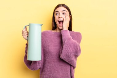 Genç İspanyol kadın mutlu, heyecanlı ve şaşırmış hissediyor. Kahve termosu kavramı