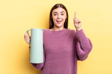 Genç İspanyol kadın bir fikri fark ettikten sonra mutlu ve heyecanlı bir dahi gibi hissediyor. Kahve termosu kavramı