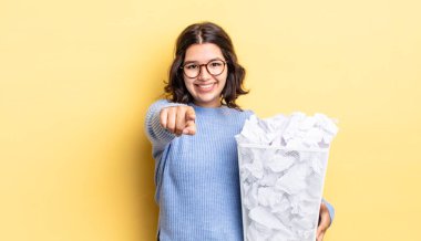 Latin asıllı genç bir kadın kameraya işaret ederek başarısız çöp konseptini seçiyor.