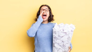 Genç İspanyol kadın kendini mutlu hissediyor, elleri ağızda bağırıyor çöp konseptinde başarısız oluyor.