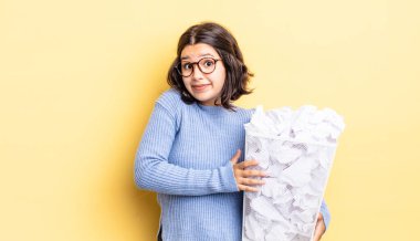 Genç İspanyol kadın omuz silkiyor, kafası karışık ve kararsız çöp konsepti