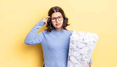 Genç İspanyol kadın şaşkın ve şaşkın hissediyor, senin çılgın başarısız çöp konseptini gösteriyor.