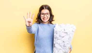 Genç İspanyol kadın gülümsüyor ve arkadaş canlısı görünüyor. Dört numara başarısız çöp konseptini gösteriyor.