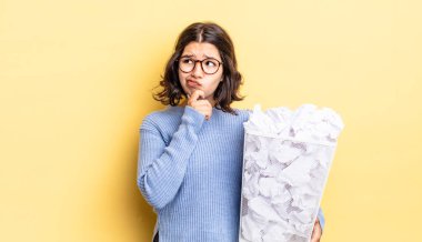 Genç İspanyol kadın düşünüyor, kuşkulu hissediyor ve kafası karışmış çöp konsepti