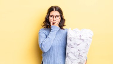 Ağzı ve gözleri sonuna kadar açık ve eli çenesinde olan genç İspanyol kadın başarısız çöp konsepti