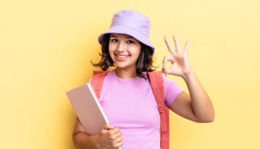 Genç İspanyol kadın kendini mutlu hissediyor, iyi bir jestle onaylıyor. okul konseptine geri dön