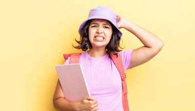 Genç İspanyol kadın stresli, endişeli ya da korkmuş hissediyor, elleri başının üstünde. okul konseptine geri dön