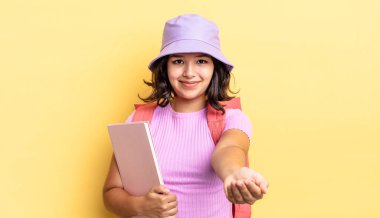 Genç İspanyol kadın mutlu bir şekilde gülümsüyor ve bir konsept sunuyor. okul konseptine geri dön