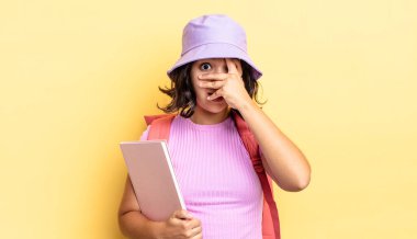 Genç İspanyol bir kadın şok olmuş, korkmuş ya da korkmuş görünüyor. Yüzü elle kapatılmış. okul konseptine geri dön