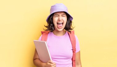 Genç İspanyol kadın agresif bir şekilde bağırıyor, çok kızgın görünüyor. okul konseptine geri dön