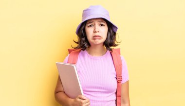 Genç İspanyol kadın üzgün ve mızmızlanıyor. Mutsuz bir bakışı var ve ağlıyor. okul konseptine geri dön