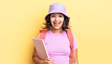 Genç İspanyol kadın mutlu ve hoş bir şekilde şaşırmış görünüyor. okul konseptine geri dön