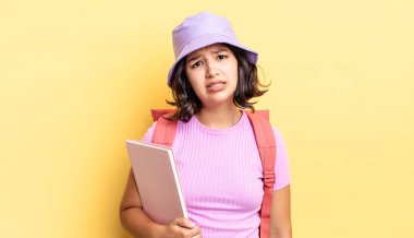 Genç İspanyol kadın şaşkın ve şaşkın hissediyor. okul konseptine geri dön