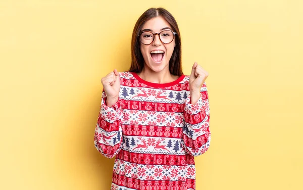 Genç İspanyol kadın şokta, gülüyor ve başarıyı kutluyor. Chistmas ve yeni yıl konsepti