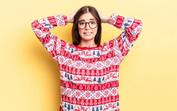 Genç İspanyol kadın stresli, endişeli ya da korkmuş hissediyor, elleri başının üstünde. Chistmas ve yeni yıl konsepti