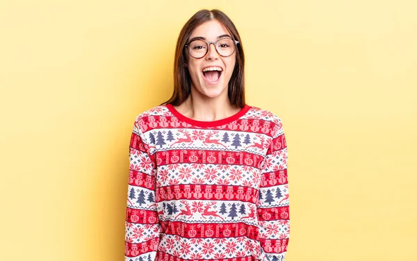 Genç İspanyol kadın mutlu ve hoş bir şekilde şaşırmış görünüyor. Chistmas ve yeni yıl konsepti