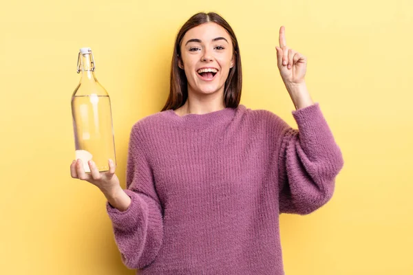 Genç İspanyol kadın bir fikri fark ettikten sonra mutlu ve heyecanlı bir dahi gibi hissediyor. su şişesi kavramı