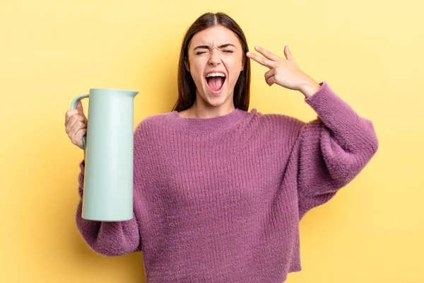 Genç İspanyol kadın mutsuz ve stresli görünüyor, intihar jesti silah işareti yapıyor. Kahve termosu kavramı