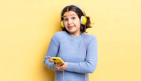 Young Hispanic Woman Shrugging Feeling Confused Uncertain Headphones Smartphone Concept — Stock Photo, Image