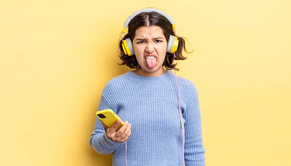 Young Hispanic Woman Feeling Disgusted Irritated Tongue Out Headphones Smartphone — Stock Photo, Image