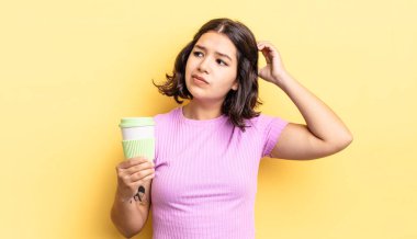 Genç İspanyol kadın şaşkın ve kafası karışık, kaşınan bir kafa hissediyor. kahve konseptini kaldır.
