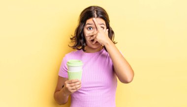 Genç İspanyol bir kadın şok olmuş, korkmuş ya da korkmuş görünüyor. Yüzü elle kapatılmış. kahve konseptini kaldır.