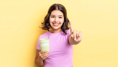 Genç İspanyol kadın gülümsüyor ve arkadaş canlısı görünüyor, bir numarayı gösteriyor. kahve konseptini kaldır.