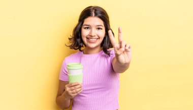 Genç İspanyol kadın gülümsüyor ve arkadaş canlısı görünüyor, iki numarayı gösteriyor. kahve konseptini kaldır.