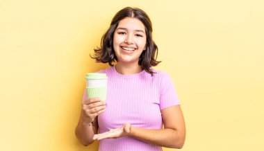 Genç İspanyol kadın neşeyle gülümsüyor, mutlu hissediyor ve bir konsept gösteriyor. kahve konseptini kaldır.