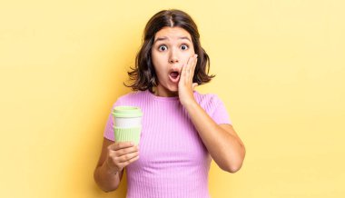 Genç İspanyol kadın şok olmuş ve korkmuş hissediyor. kahve konseptini kaldır.