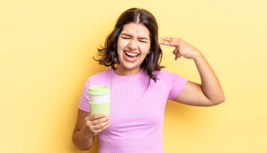 Genç İspanyol kadın mutsuz ve stresli görünüyor, intihar jesti silah işareti yapıyor. kahve konseptini kaldır.