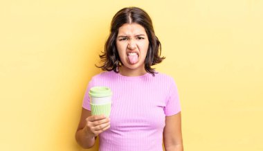 Genç İspanyol kadın iğreniyor, sinirleniyor ve dili dışarı çıkıyor. kahve konseptini kaldır.