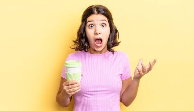 Genç İspanyol kadın şok olmuş ve şaşırmış hissediyor. kahve konseptini kaldır.