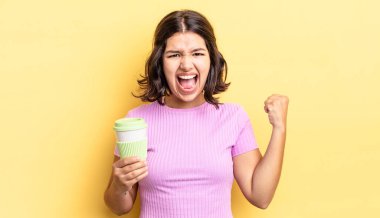 Genç İspanyol kadın öfkeli bir ifadeyle agresif bir şekilde bağırıyor. kahve konseptini kaldır.