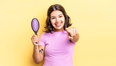 Genç İspanyol kadın kamerayı göstererek seni seçiyor. saç fırçası konsepti