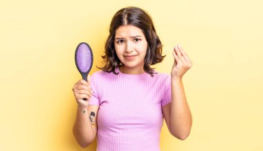 Genç İspanyol kadın kapiş ya da para hareketi yapıyor, sana ödemeni söylüyor. saç fırçası konsepti