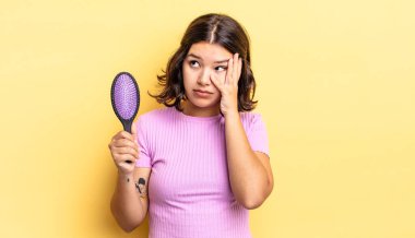 Genç İspanyol bir kadın bıkkın, hayal kırıklığına uğramış ve yorucu bir günün ardından uykulu hissediyor. saç fırçası konsepti