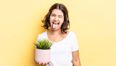 Neşeli ve asi tavırları olan, şaka yapan ve dilini dışarı çıkaran genç İspanyol bir kadın. büyüme kavramı