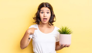 Genç İspanyol kadın şok olmuş ve ağzı açık, kendini işaret ederek şaşırmış görünüyor. büyüme kavramı