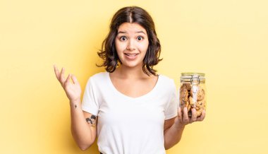 Genç İspanyol kadın kendini mutlu hissediyor, bir çözüm ya da fikir bulduğuna şaşırıyor. kurabiye şişesi konsepti