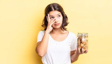 Genç İspanyol bir kadın bıkkın, hayal kırıklığına uğramış ve yorucu bir günün ardından uykulu hissediyor. kurabiye şişesi konsepti