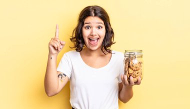 Genç İspanyol kadın bir fikri fark ettikten sonra mutlu ve heyecanlı bir dahi gibi hissediyor. kurabiye şişesi konsepti