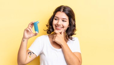 Genç İspanyol kadın mutlu ve kendinden emin bir ifadeyle gülümsüyor. Elleri çenesinde. astım konsepti