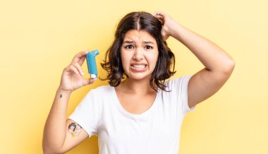 Genç İspanyol kadın stresli, endişeli ya da korkmuş hissediyor, elleri başının üstünde. astım konsepti