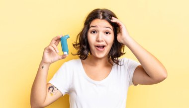 Genç İspanyol kadın mutlu, şaşkın ve şaşırmış görünüyor. astım konsepti