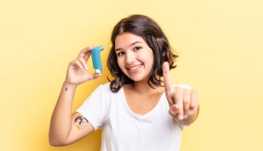 Genç İspanyol kadın gururla gülümsüyor ve kendinden emin bir numara oluyor. astım konsepti