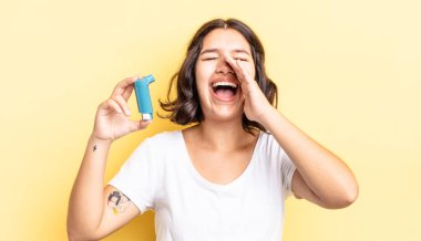 Genç İspanyol kadın kendini mutlu hissediyor, elleri ağzının kenarında bağırıyor. astım konsepti